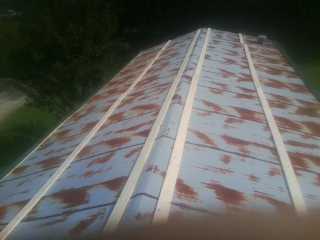 Rusted metal roof panels with new wood purlins before replacement — Storm Damage Roof Repair in Turpin by Roofing Brothers