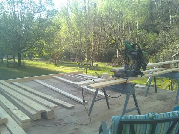 Miter saw and framing lumber on a deck under construction in Turpin