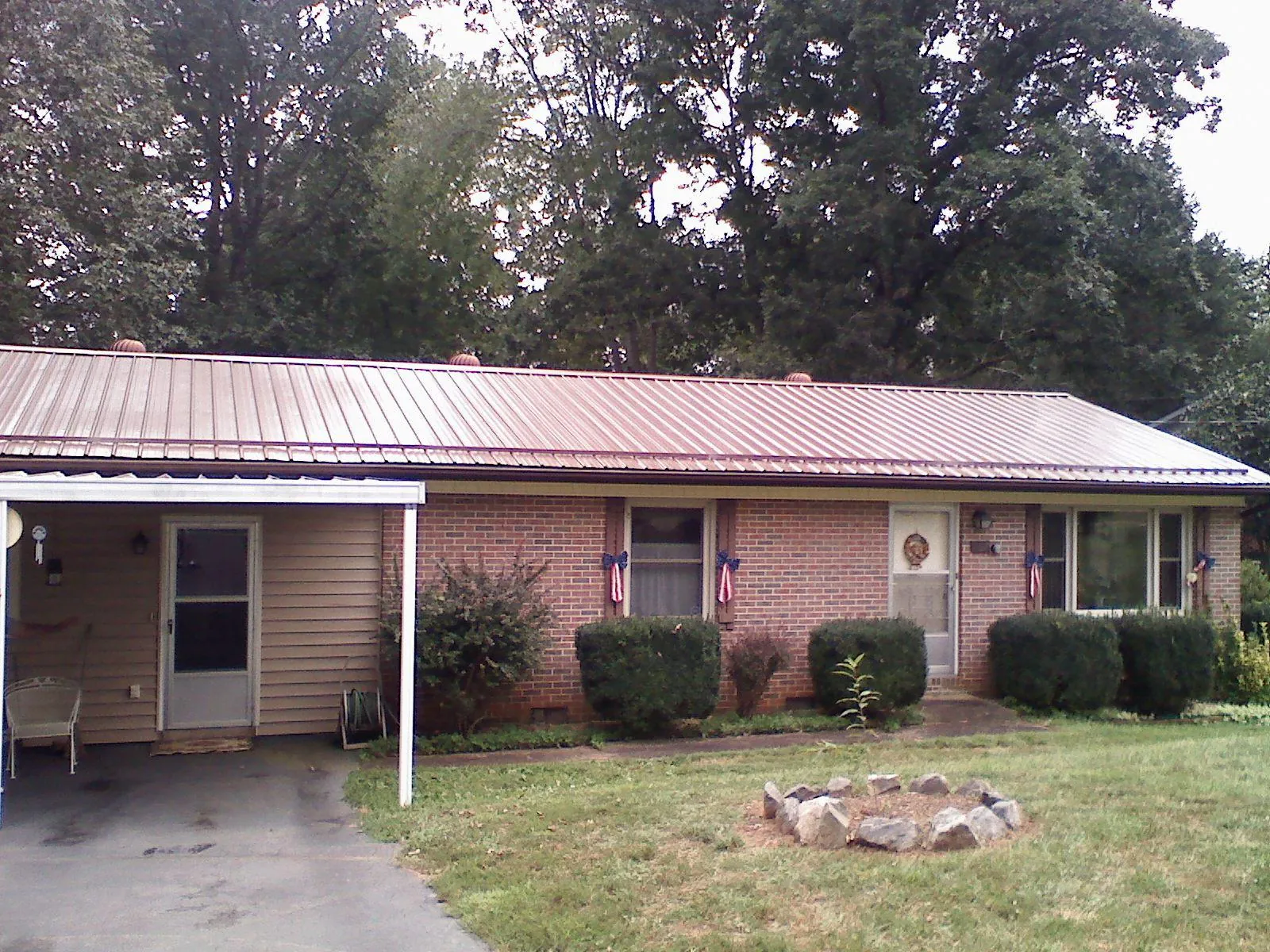 Bronze metal roof and carport on a brick ranch home — Roof Repair work by our crew in Turpin